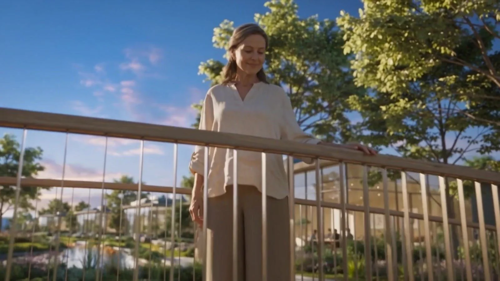 A resident at her balcony rail, looking out over the trees in evening light